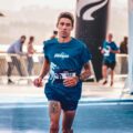 Focused runner finishing a marathon on a sunny day, showcasing energy and endurance.