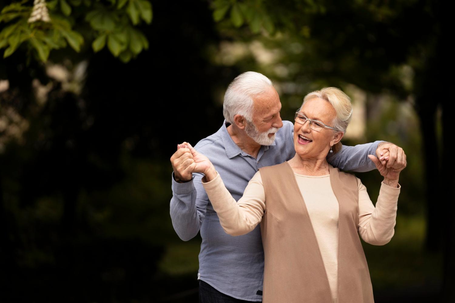 Two old people happy dancing in the park after EBOO Therapy